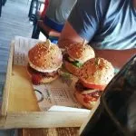 Wooden table with delicious burgers